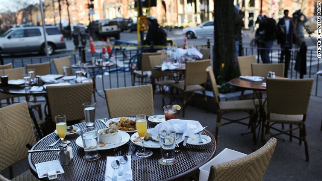 The unfinished meals of fleeing customers are left on tables at an outdoor restaurant in Boston on April 16.