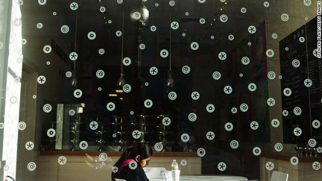 A woman sits alone at a Boston cafe on April 16.