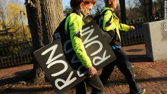 A woman carries a sign she made to support her runner husband near the scene of the bombings.