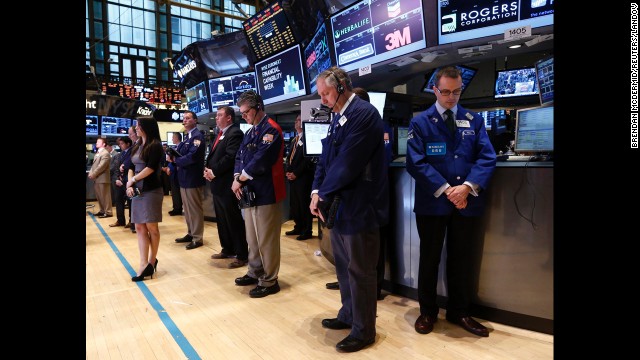 Traders observe a moment of silence on Tuesday before the opening bell on the floor of the New York Stock Exchange.