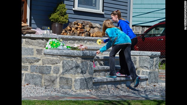 Two young girls leave flowers on the steps outside the home of 8-year-old Martin Richards, who was killed in one of the explosions at the marathon. 