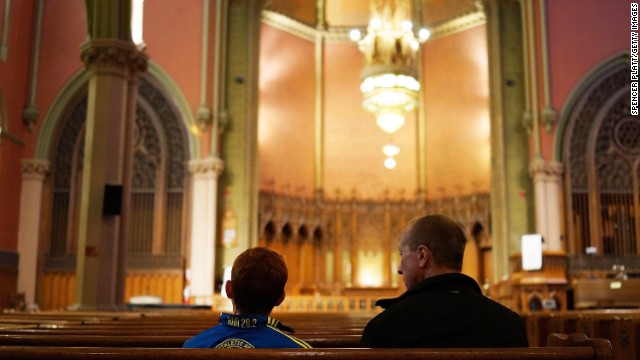 A young runner, left, collects his thoughts on Tuesday, April 16, in a church blocks away from the scene of the bombing attack at the Boston Marathon. The city was quiet the day after the tragedy.