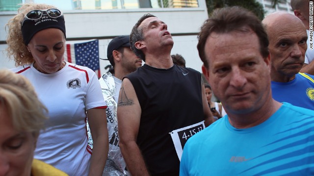 Five-time Boston Marathon runner Jose Sotolongo, center, reacts during a moment of silence at the Baptist Health South Florida Brickell Run Club event in Miami on April 16.