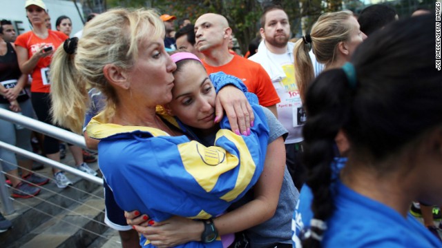 Runners Judy Adler, left, and her daughter, Rachel Schapiro, embrace during a moment of silence at the Baptist Health South Florida Brickell Run Club event organized on April 16 in Miami in honor of victims of the Boston Marathon bombings. 