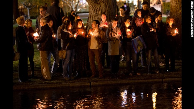 Mourners gather on the edge of the pond in the Boston Public Gardens for a candlelight vigil on April 16.