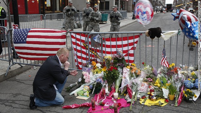 Mike Vitale, who lives in the Boston area, prays beside a makeshift memorial at a roadblock at the end of Boylston Street.