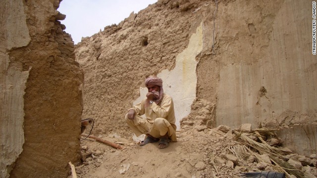 A Pakistani man sits on the remains of his mud house in Mashkell on Wednesday.
