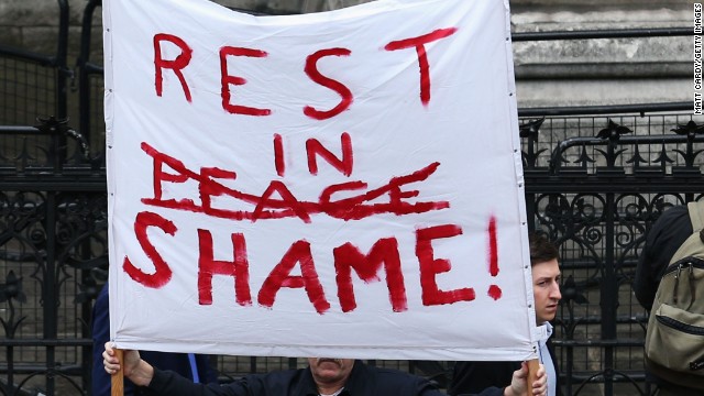 A protester holds a banner at the Church of St. Clement Danes in London.