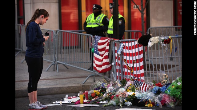 A woman looks at memorials left at the scene of the Boston Marathon explosions.