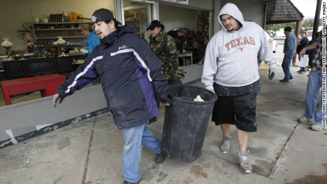 Workers clean up shattered windows at a store in West, Texas, on April 18.