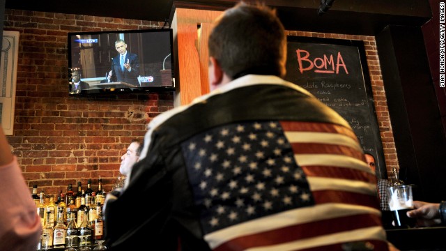 A man at the BoMA restaurant across the street from the Cathedral of the Holy Cross in Boston watches President Obama speak on television at the cathedral honoring the victims of the Boston Marathon bombings on April 18. 