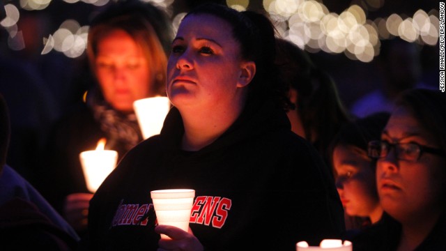 People hold candles as they listen to a speaker during a vigil in Somerville, Massachusetts, on April 18.