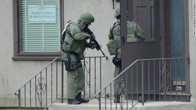 SWAT officers check a door with guns ready on Friday.
