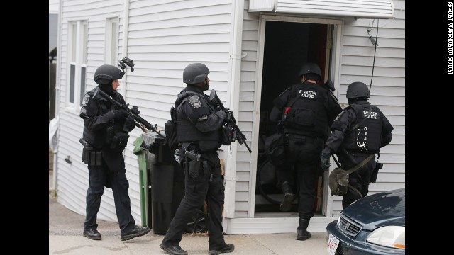 SWAT team members search for the suspect at a residential building