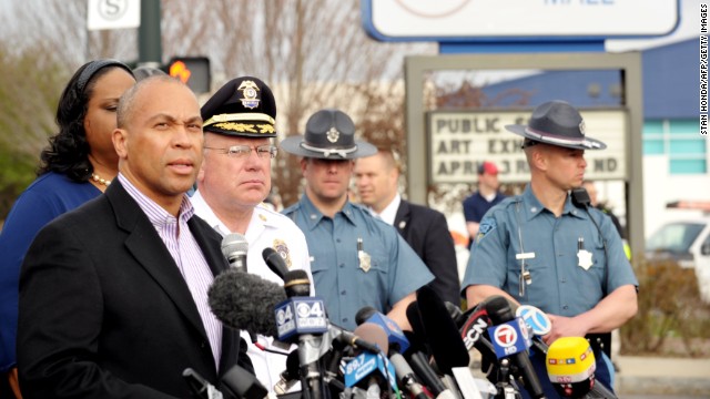Massachusetts Gov. Deval Patrick, left, speaks to the media at a shopping mall on the perimeter of a locked-down area during the search on Friday.