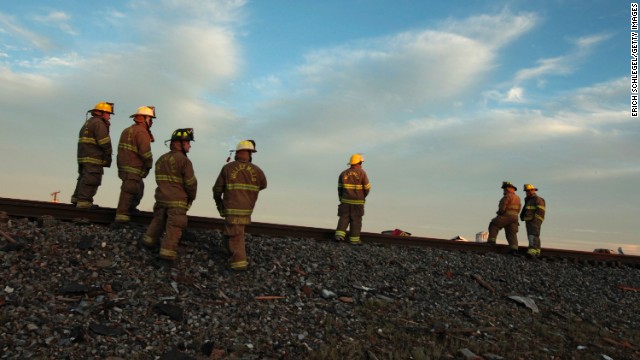 Fire personnel check out the railroad tracks near the fertilizer plant on April 18.