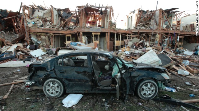 The remains of a car sit in front of an apartment complex destroyed after the fertilizer plant blast. 