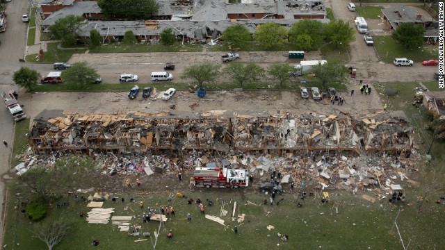 Search and rescue workers comb through what remains of a 50-unit apartment building, in foreground, and a nursing home on April 18.