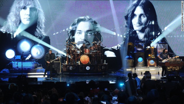 Alex Lifeson, Neil Peart, and Geddy Lee of Rush perform onstage.