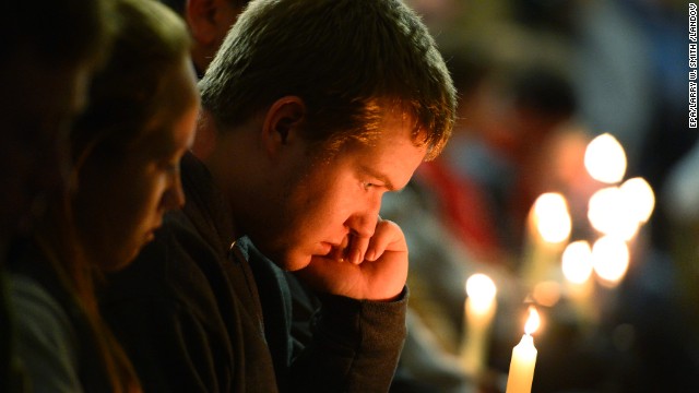 A young man holds a candle during the vigil. 