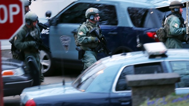 Members of a police SWAT team run to the scene where the suspect was hiding on April 19.