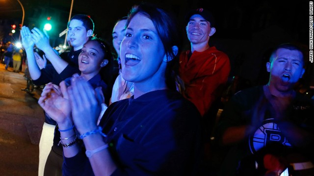 Spectators celebrate as law enforcement officers leave the scene on April 19 near Franklin Street.