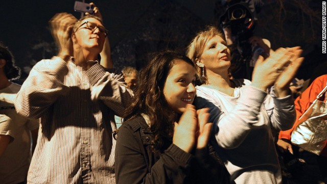 Onlookers applaud first responders departing the scene at the end of the manhunt on April 19.