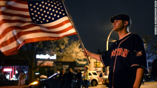 A man waves a U.S. flag in Watertown on April 19. 