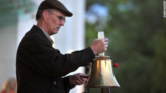 A man rings a bell at the vigil in Huntsville on April 19.