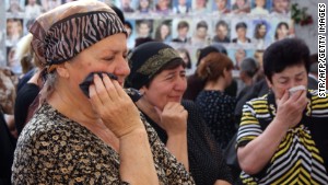 Russians cry inside the Beslan school gym remembering when at least 300 kids and parents were killed by Chechen rebels in 2004. \n