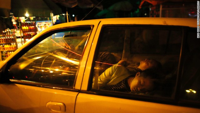 Chinese residents sleep in a car on Sunday to avoid danger from aftershocks.