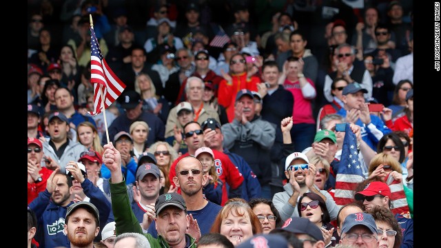 A man holds an American flag at ceremonies before the Saturday game in Boston.