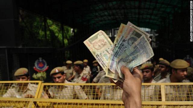 An Indian protester waves Indian currency toward police at a demonstration on April 21. Protests have swept through New Delhi since Friday. Many demonstrators are members of a political party of Arvind Kejriwal, a leading anti-corruption activist.