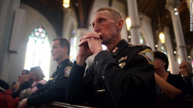 Boston Police Department Superintendent William Evans, right, kneels during the service at the Cathedral of the Holy Cross on April 21.