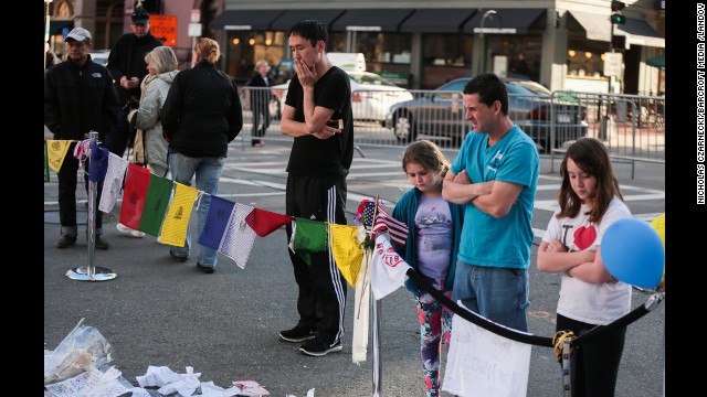 The makeshift memorial honoring the victims of the Boston Marathon explosions on Boylston Street continues to grow as onlookers gather on April 21.