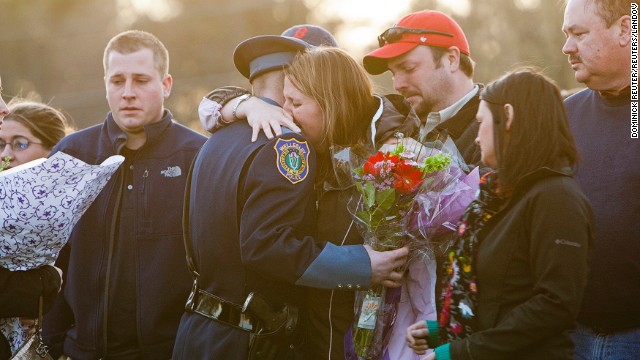 Nicole Collier Lynch, center, sister of slain MIT police officer Sean Collier, hugs a Wellesley police officer during a vigil at the Town Common in Wilmington, Massachusetts, on Saturday, April 20. Collier, 26, was shot multiple times in his car on Thursday night as Boston Marathon bombing suspects Dzhokhar Tsarnaev and his brother Tamerlan tried to evade capture.