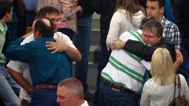 Residents embrace after a Sunday service at St. Mary's Catholic Church on April 21, four days after the deadly explosion.