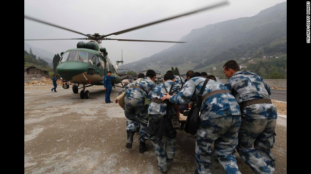 Rescuers evacuate an injured survivor onto a military helicopter on Sunday.
