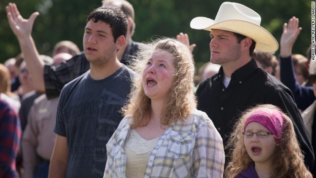 Vanna Wainwright and her daughter Breanna take part in an open air Sunday service on April 21. Members of the First Baptist Church held their service in an open air field after their church was damaged from the explosion. 