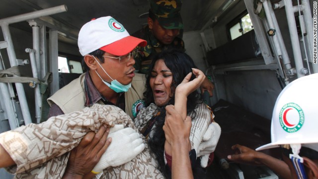 A rescue worker carries a worker to an ambulance on April 24.