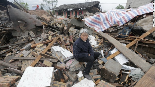 A woman sits on debris in Ya'an on Tuesday, April 23.