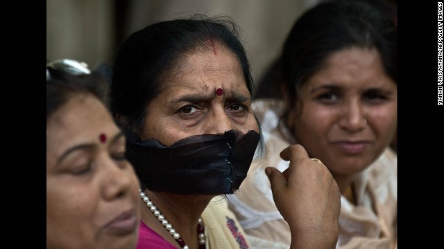 A woman covers her mouth with a black cloth during Tuesday's protest in New Delhi.