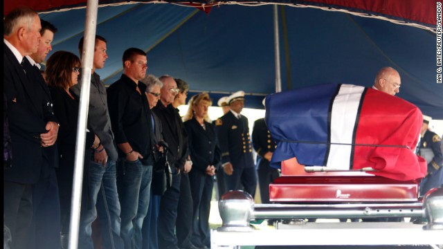 Family and friends stand in front of Harris' casket at the cemetery on April 24.