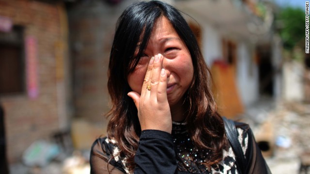 A woman who lost her son in the earthquake cries in front of her damaged home in Ya'an on April 24.