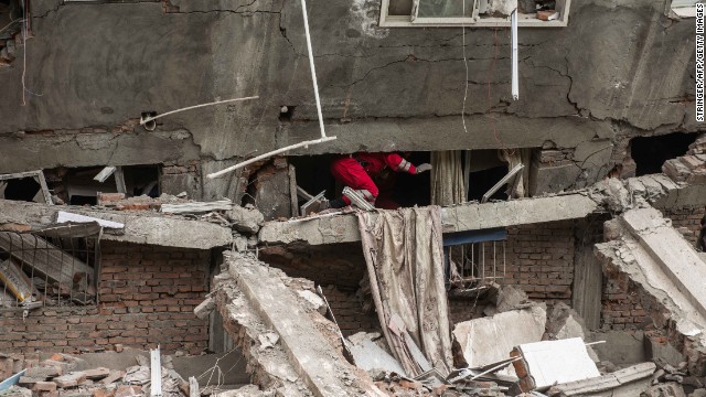 Rescuers check a collapsed building in Lingguan township in Ya'an.