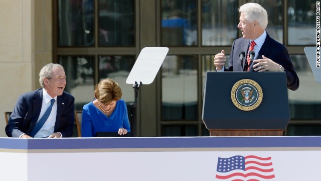 Former President George W. Bush and former first lady Laura Bush laugh during former President Bill Clinton's speech.