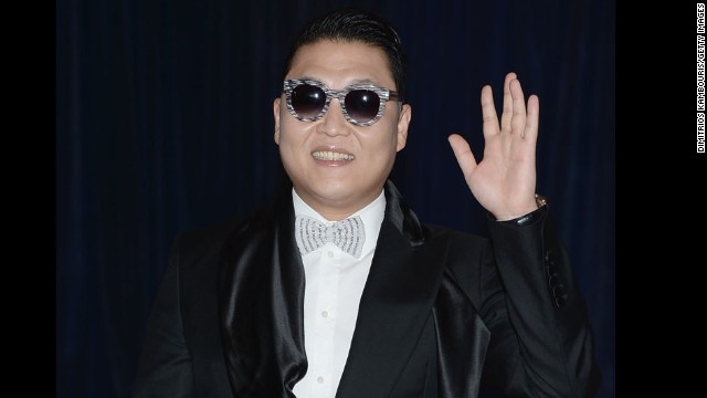 South Korean singer Psy, known for his song "Gangnam Style," waves from the red carpet.