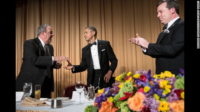 Fox News Vice President Michael Clemente shakes Obama's hand as Fox News correspondent Ed Henry watches.