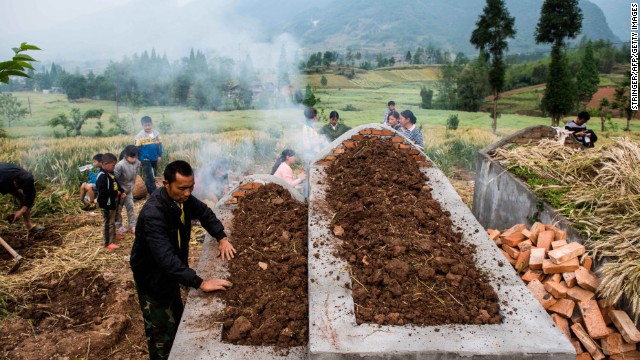 People pay their respects at a newly built grave in Ya'an, China, on Saturday, April 27, one week after a 6.6-magnitude earthquake. More than 190 people died and thousands were injured after the quake struck China's southwest Sichuan province on April 20, state media reported.