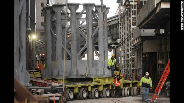 Workers prepare the first piece of the spire to be hoisted atop the One World Trade Center on December 12.